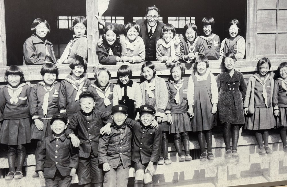 A happy class with their teacher shortly before the bomb was dropped.